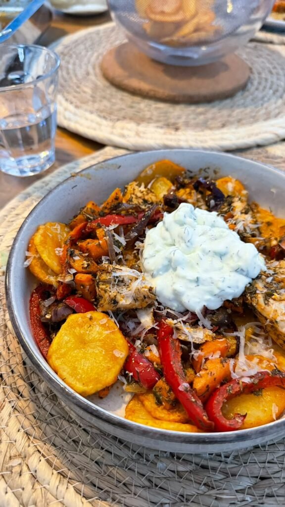 Griekse kip-aardappelbowl met paprika, rode ui, wortel en tzatziki met kwark